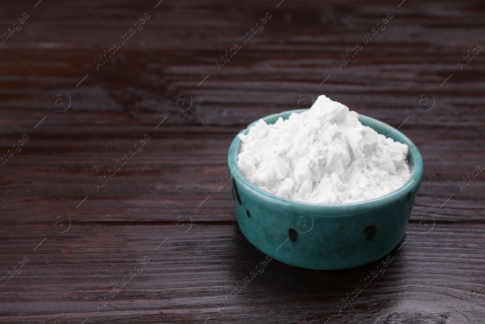 Photo of Starch in bowl on wooden table, closeup. Space for text