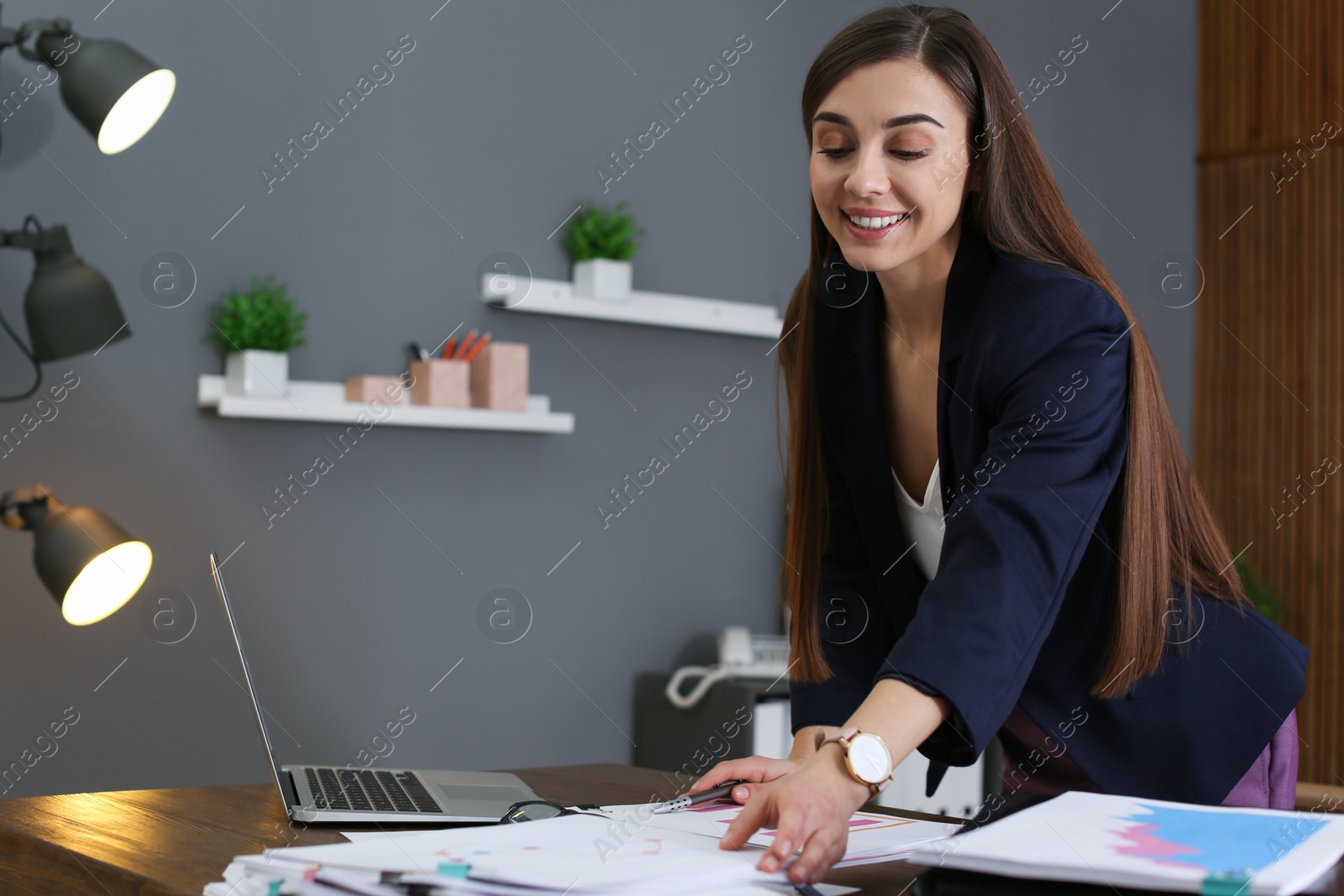 Photo of Beautiful businesswoman working with documents at table in office