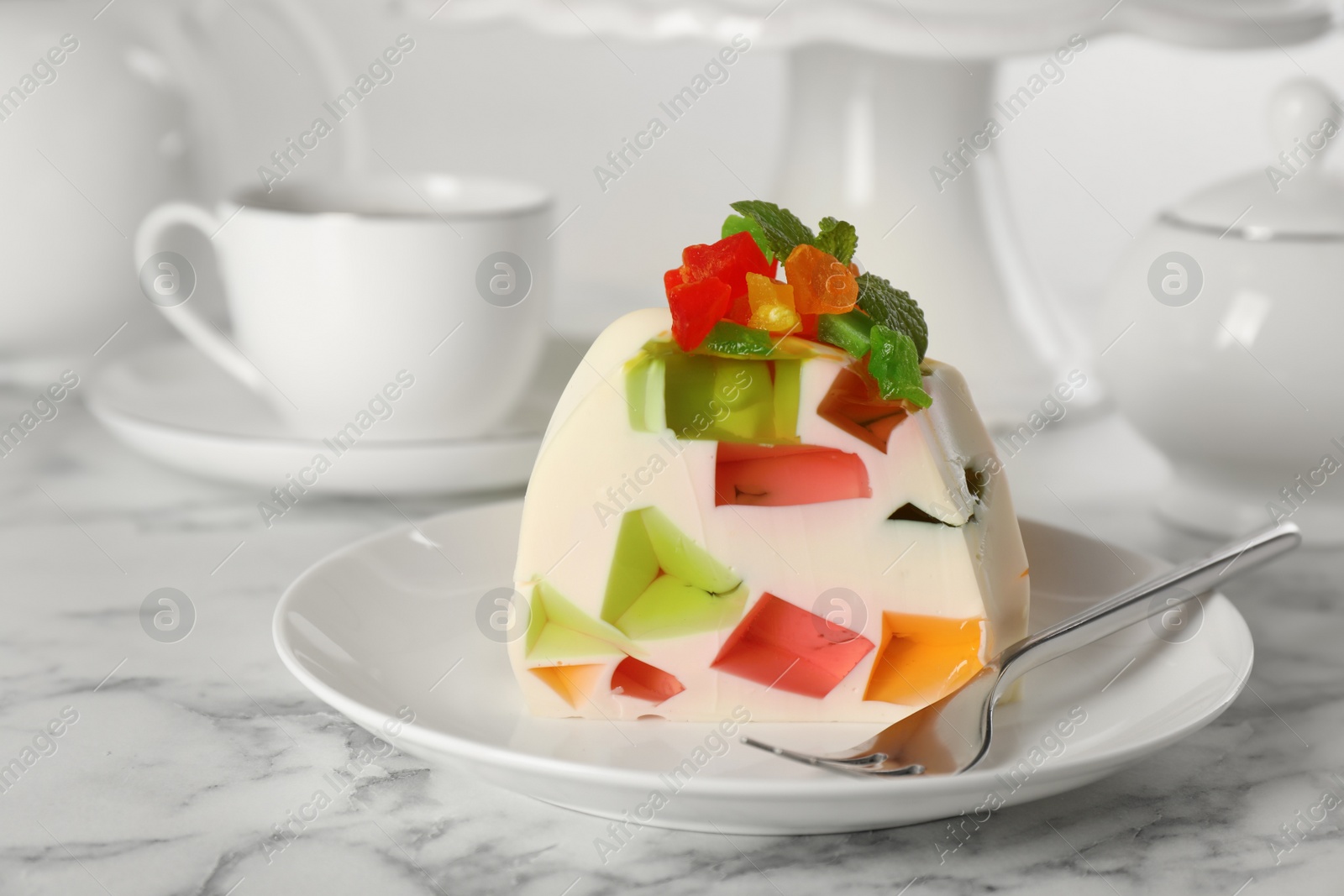 Photo of Delicious broken glass jelly dessert on white marble table