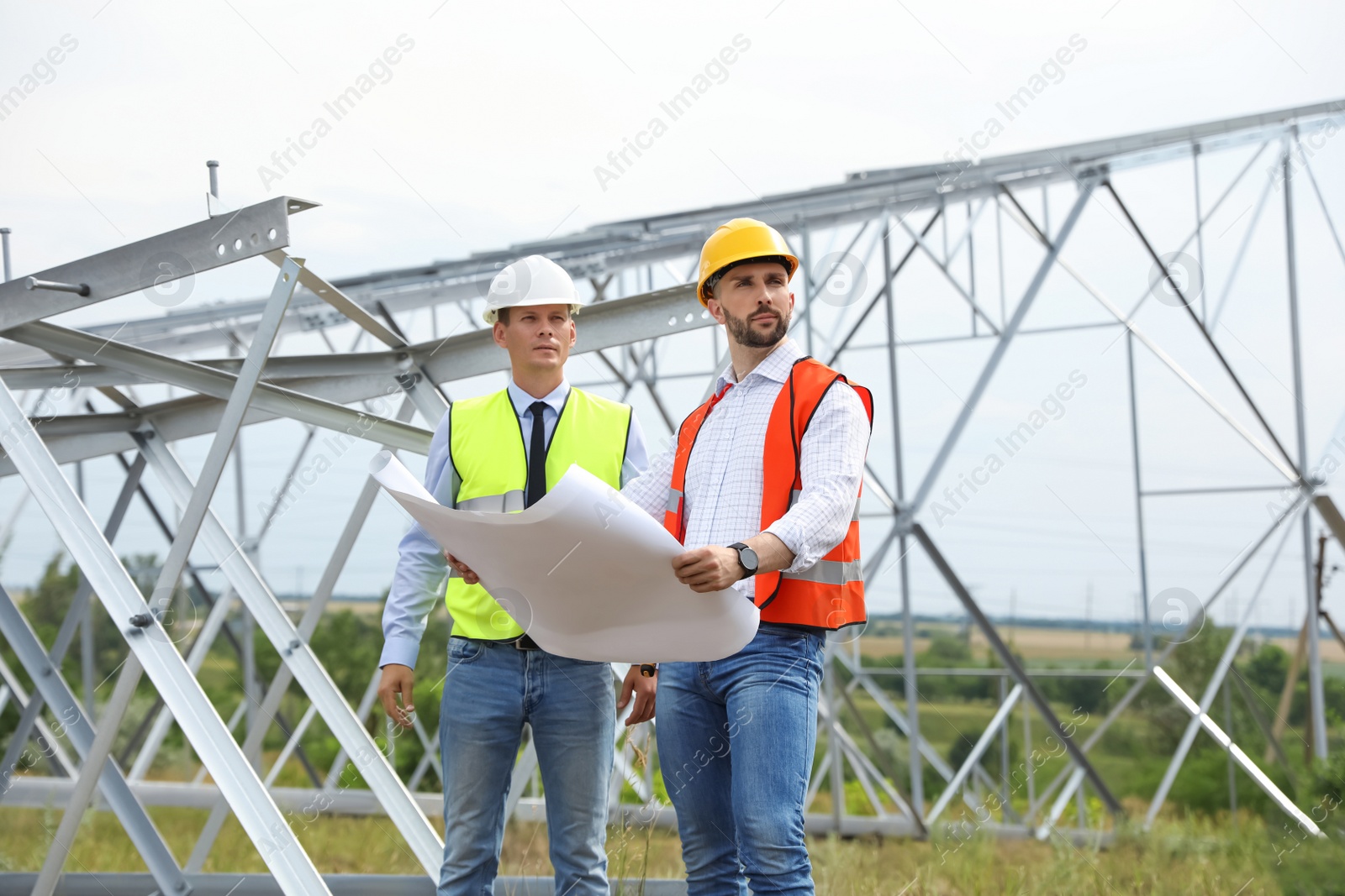 Photo of Professional engineers working on installation of electrical substation outdoors