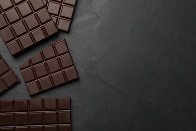Photo of Pieces of tasty chocolate bars on grey table, flat lay. Space for text