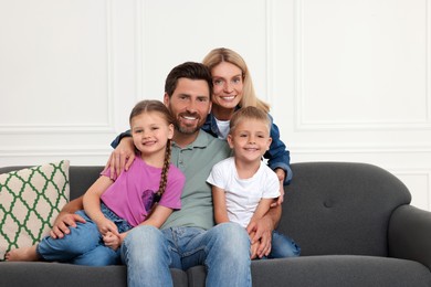 Photo of Portraithappy family with children on sofa at home