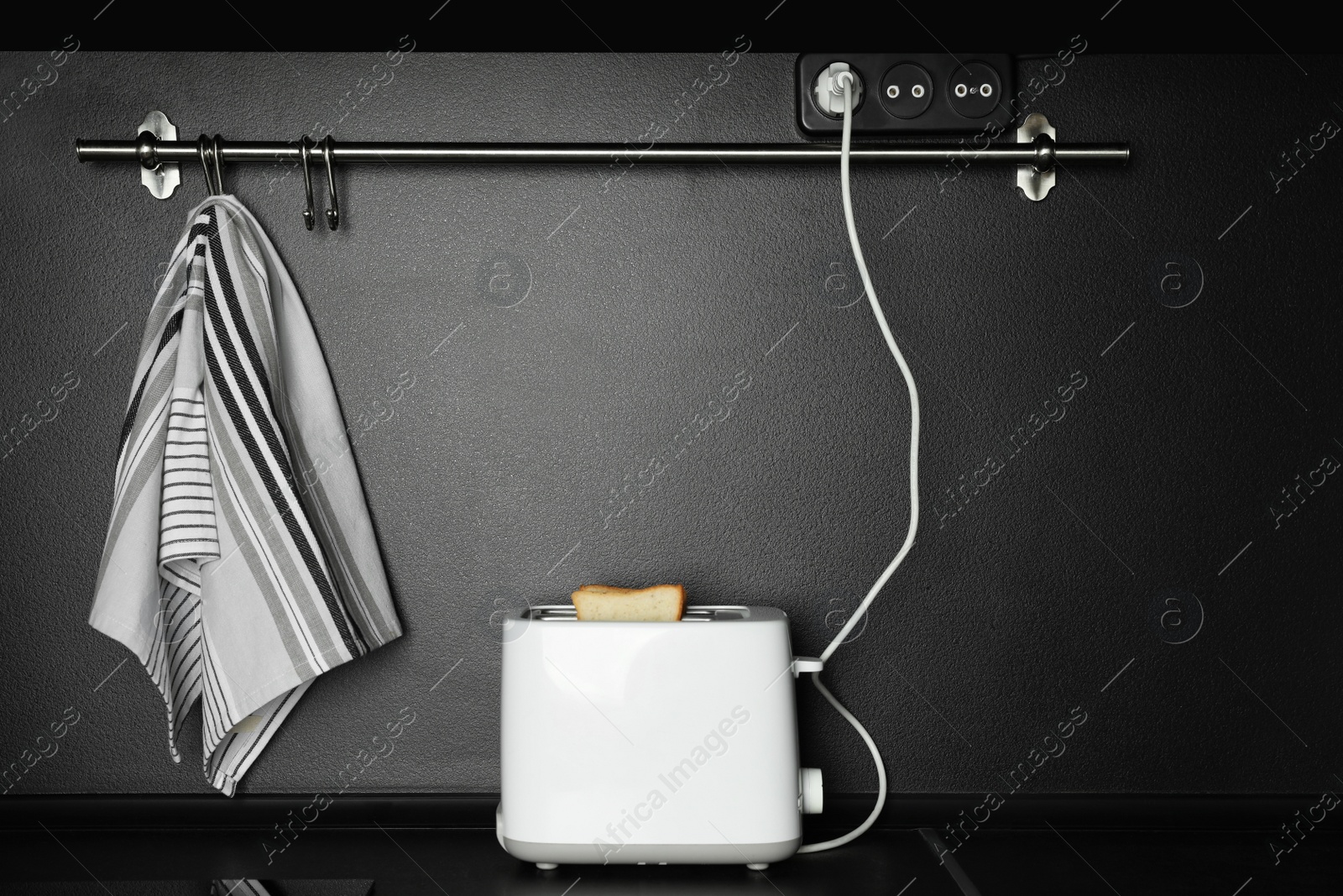 Photo of Modern toaster on black countertop in kitchen