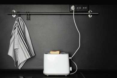 Modern toaster on black countertop in kitchen