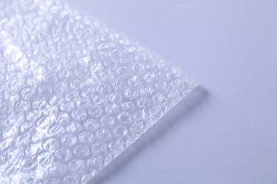 Photo of Transparent bubble wrap on gray background, closeup. Space for text