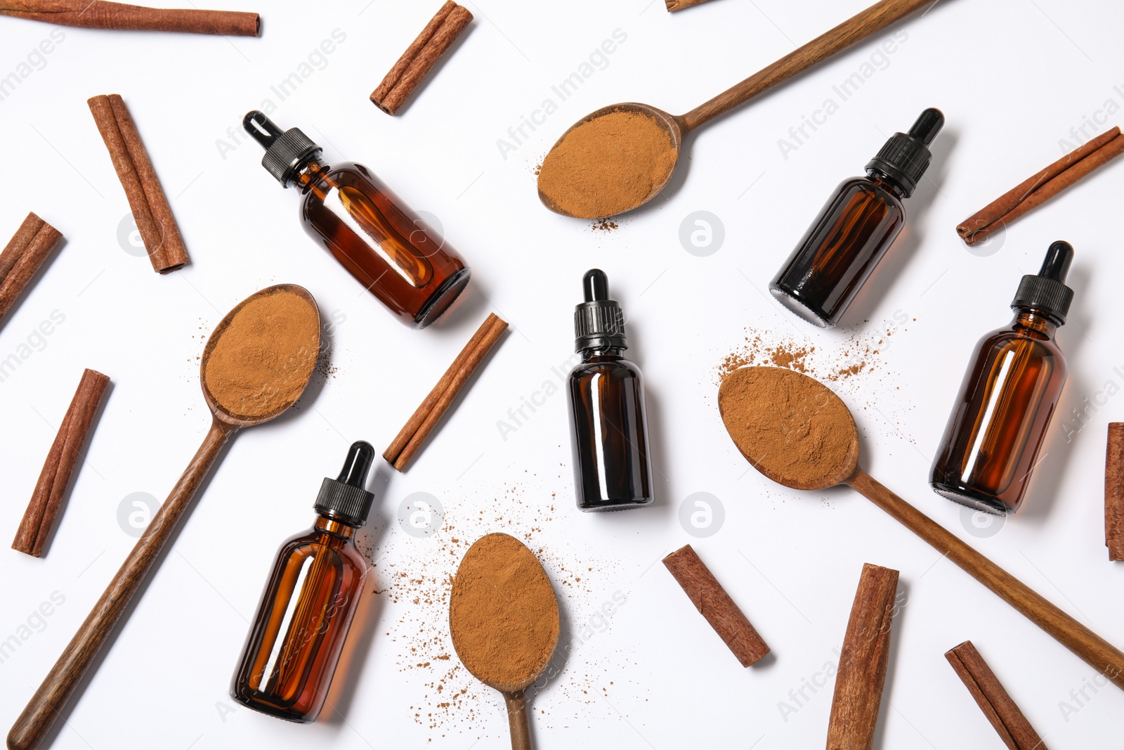 Photo of Flat lay composition with cinnamon essential oil on white background