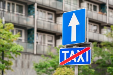 Photo of Traffic signs One Way Road and End Of Taxi Stand on city street, space for text