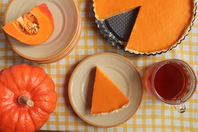 Photo of Delicious homemade pie, pumpkins and cup of tea on table, flat lay