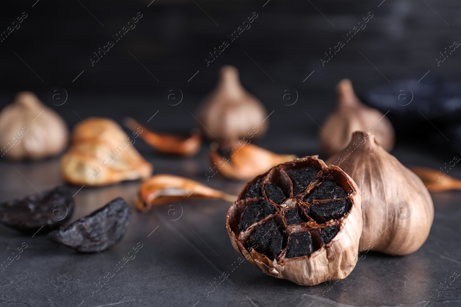 Photo of Aged black garlic on table. Space for text