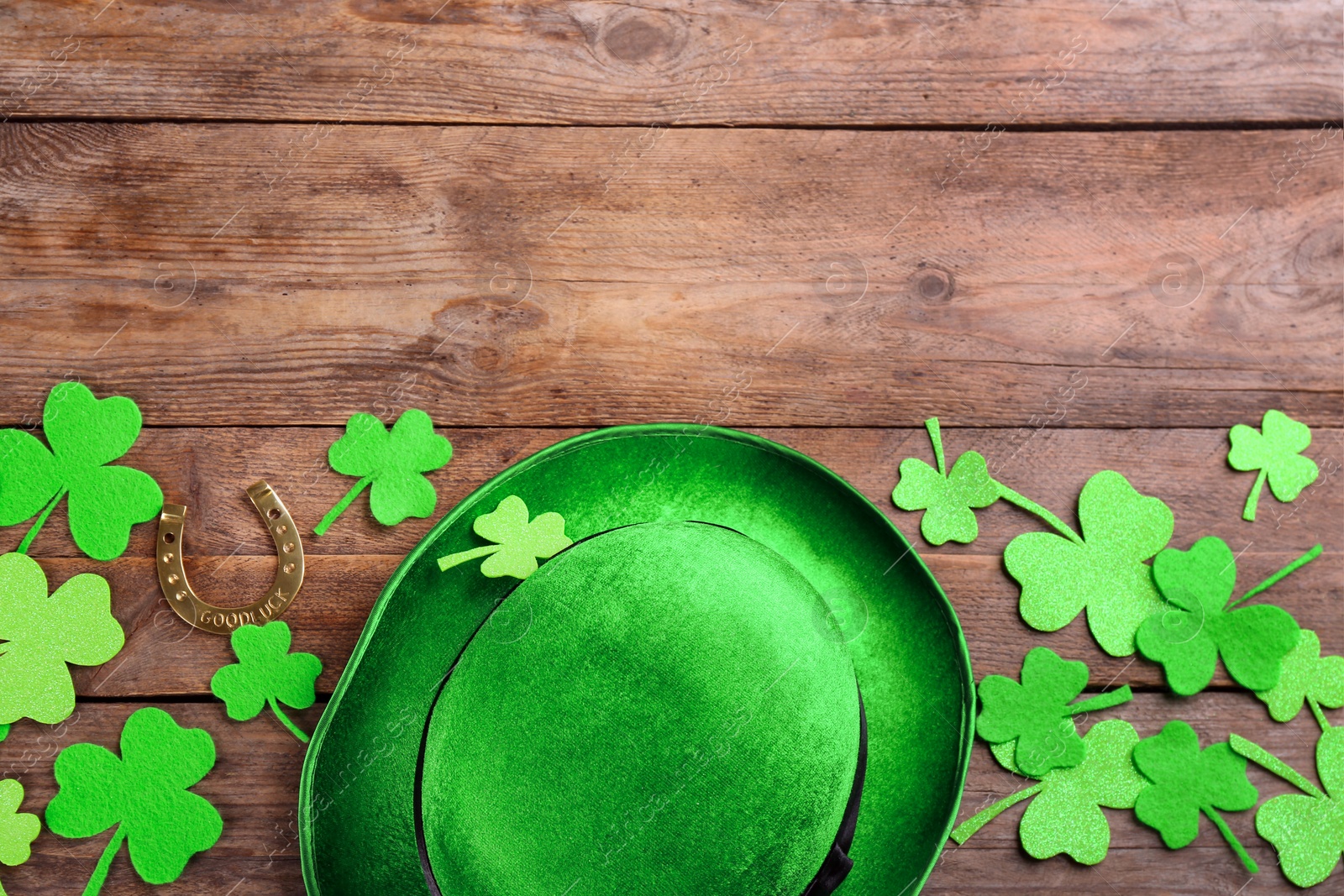 Photo of Leprechaun's hat and St. Patrick's day decor on wooden background, flat lay. Space for text