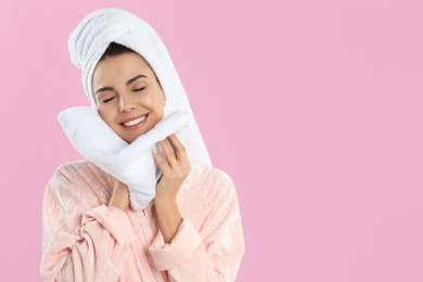 Photo of Young woman wiping face with towel on pink background. Space for text