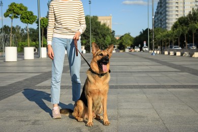 Photo of Woman with her aggressive dog on city street, closeup