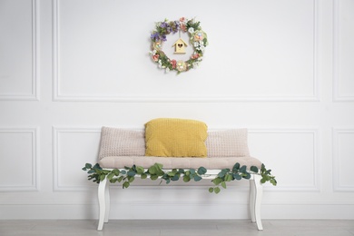 Photo of Elegant Easter photo zone with floral decor and bench indoors