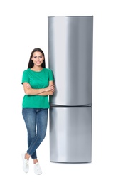Photo of Young woman near closed refrigerator on white background