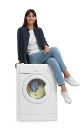 Photo of Beautiful woman sitting on washing machine against white background