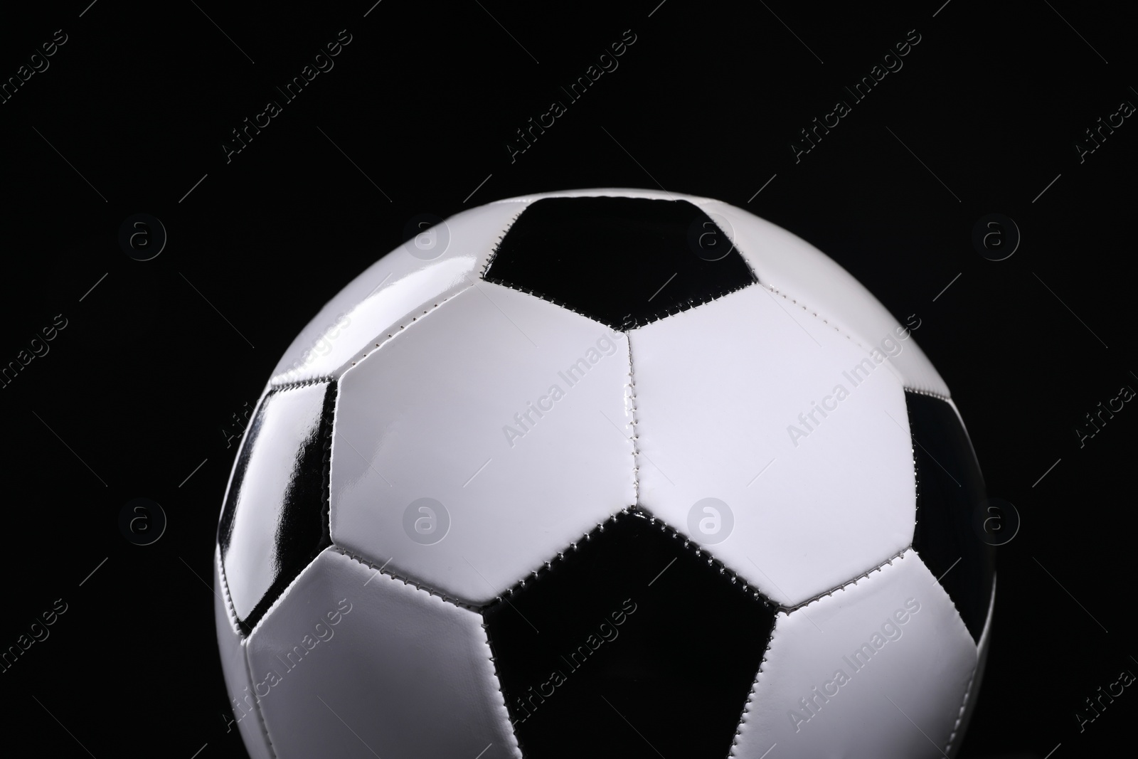 Photo of One soccer ball on black background, closeup. Sports equipment