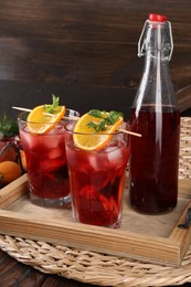 Bottle and glasses of delicious refreshing sangria on wooden table