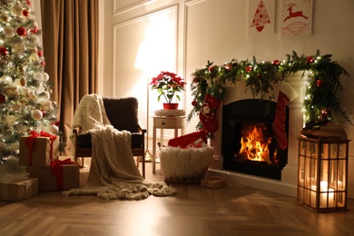 Stylish room interior with fireplace and beautiful Christmas tree