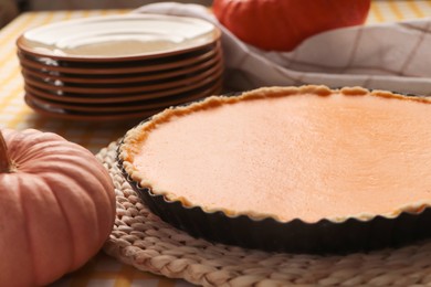 Photo of Delicious homemade pumpkin pie in baking dish on table