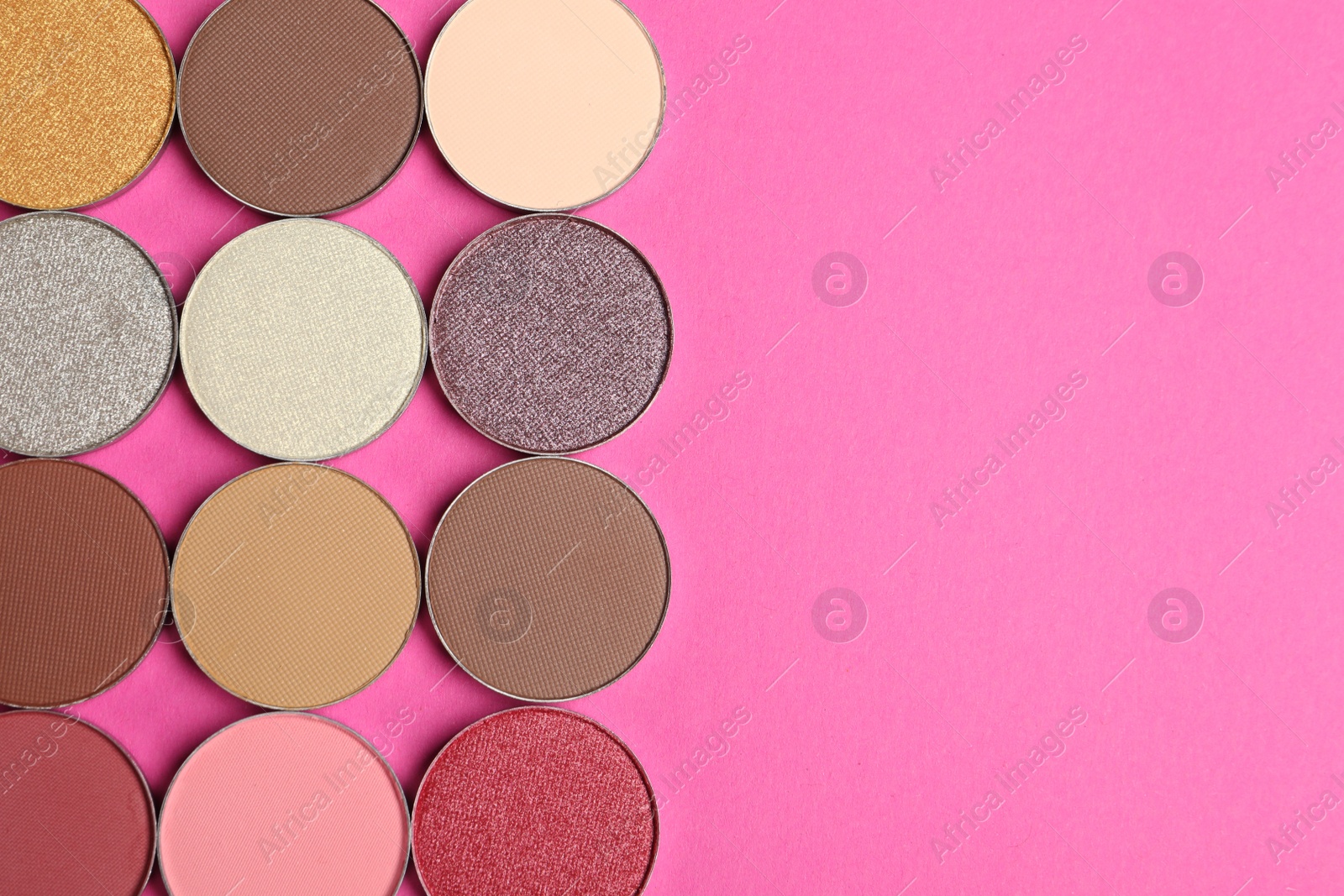 Photo of Beautiful eye shadow refill pans on pink background, flat lay. Space for text