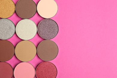 Photo of Beautiful eye shadow refill pans on pink background, flat lay. Space for text