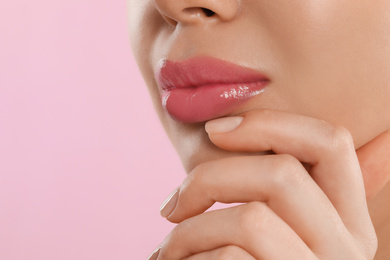 Young woman with beautiful full lips on pink background, closeup