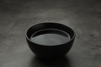 Photo of Black bowl with water on grey table