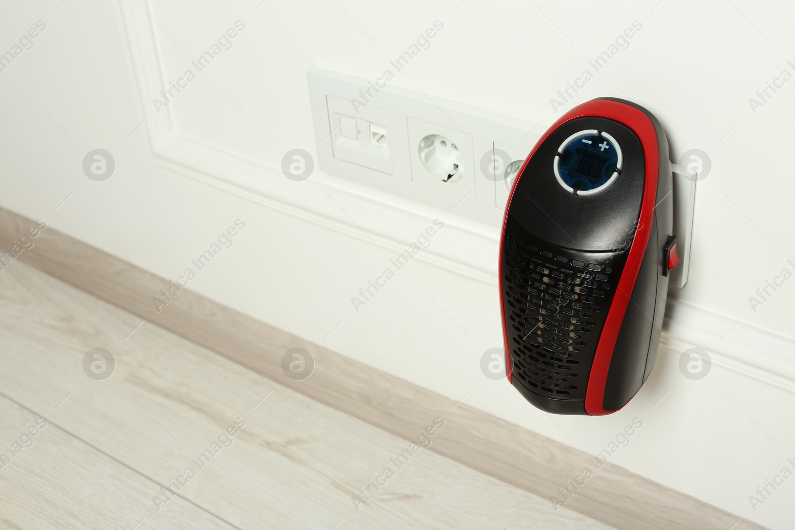 Photo of Modern compact electric heater charging indoors, space for text