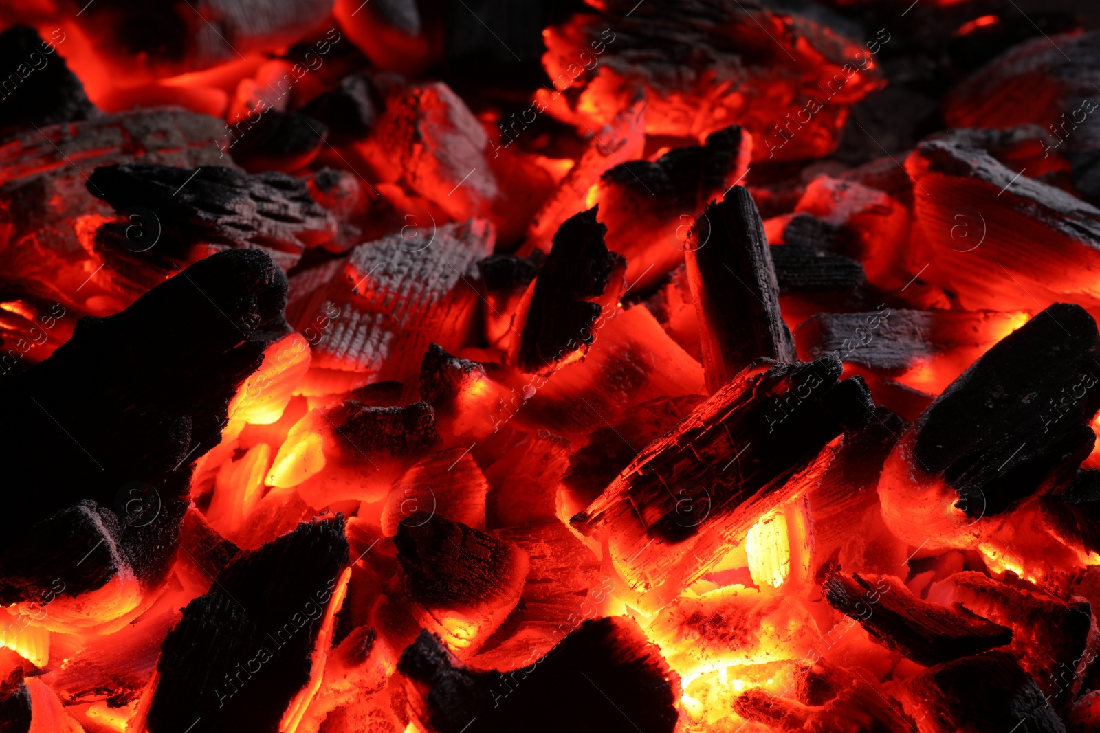 Photo of Pieces of hot smoldering coal as background, closeup