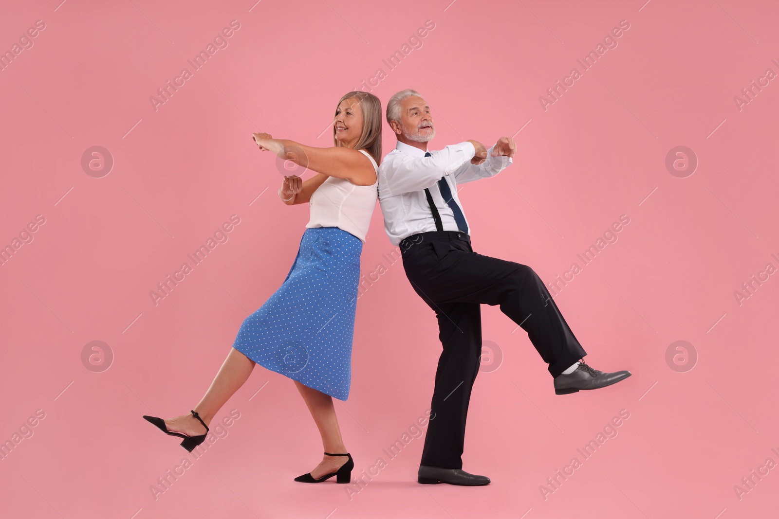 Photo of Senior couple dancing together on pink background