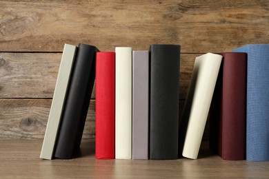 Photo of Many different hardcover books on wooden table