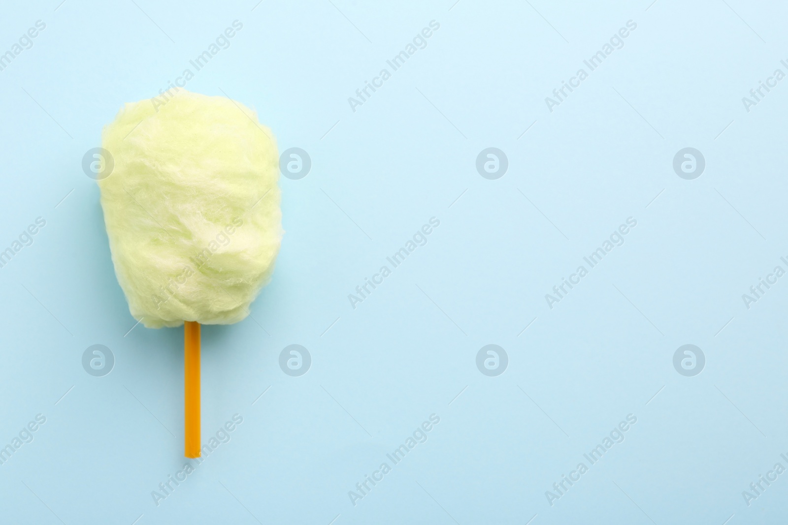 Photo of Sweet cotton candy on light blue background, top view. Space for text