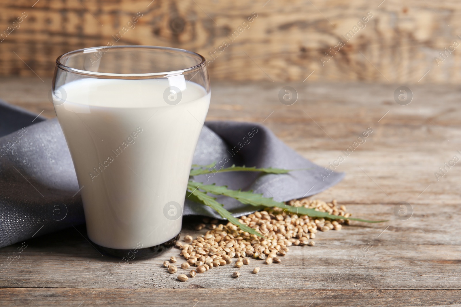 Photo of Glass of hemp milk on wooden table