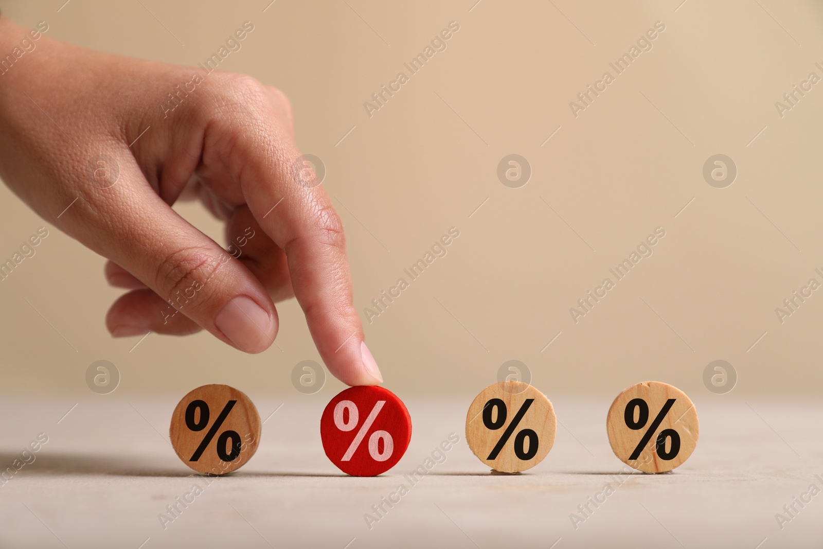 Image of Best mortgage interest rate. Woman touching red wooden circle with percent sign on table, closeup