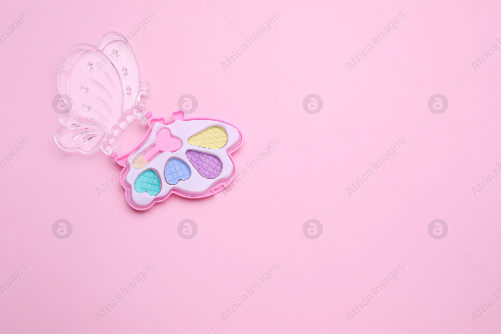 Photo of Decorative cosmetics for kids. Eye shadow palette on pink background, top view. Space for text