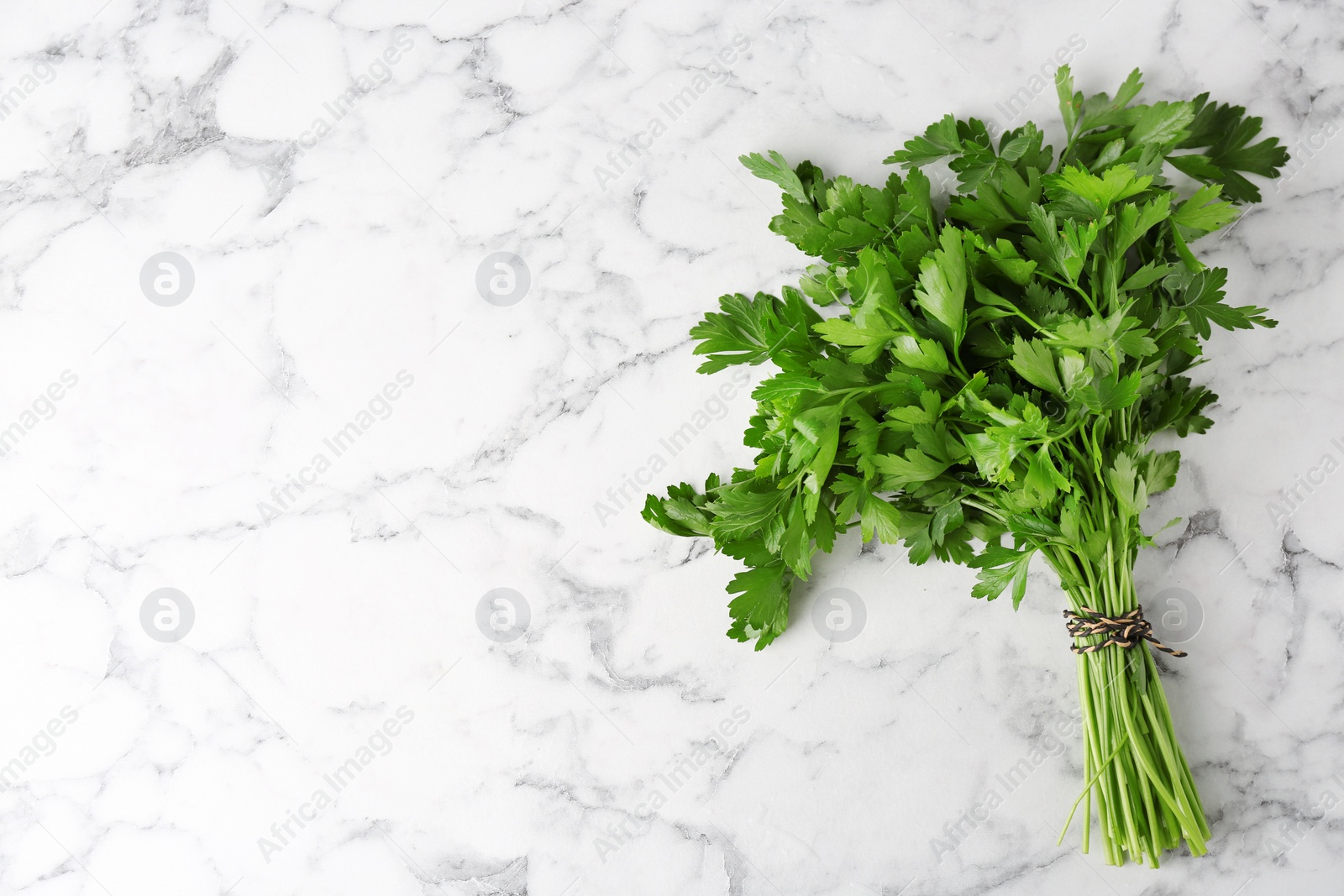 Photo of Fresh green parsley and space for text on marble background, top view