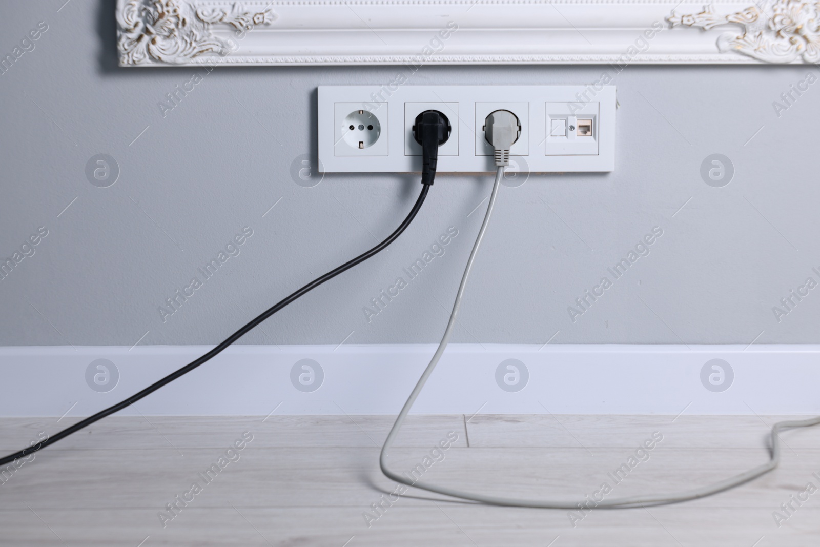 Photo of Power sockets and electric plugs on grey wall