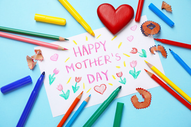 Flat lay composition with drawing for Mother's day on light blue background