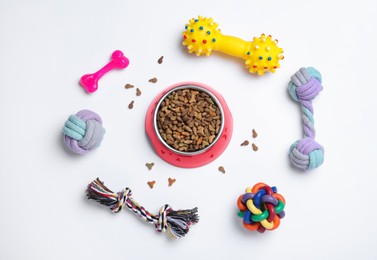 Photo of Different pet toys and feeding bowl on white background, top view