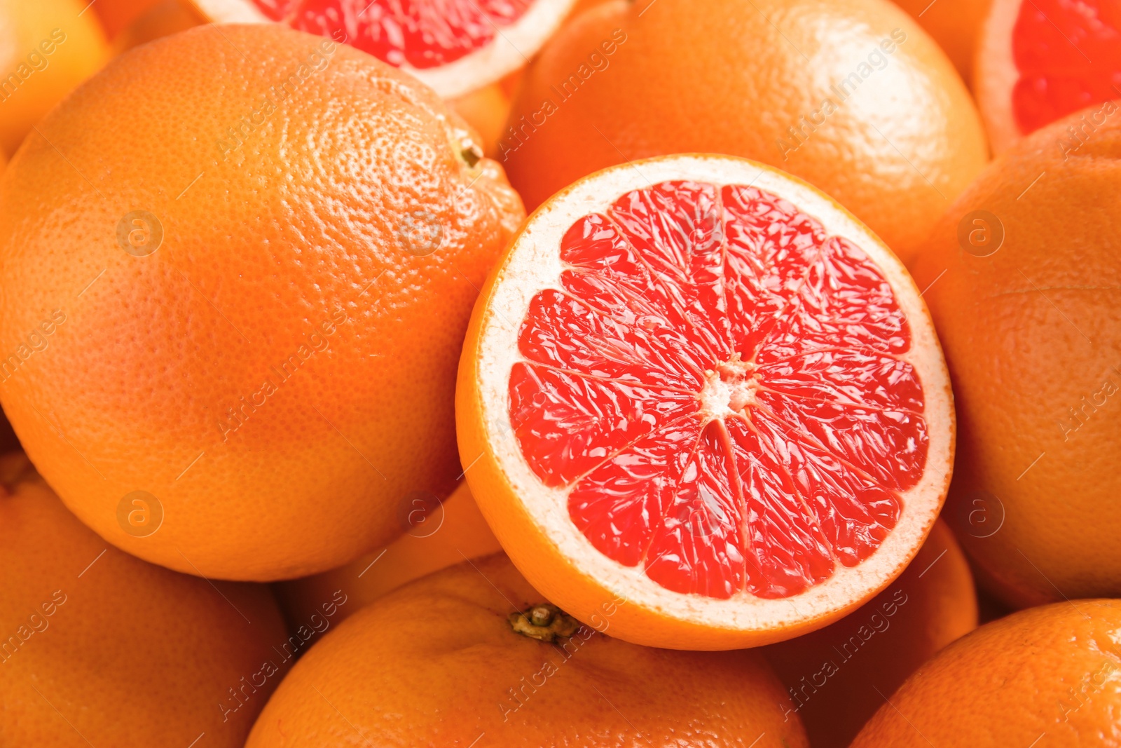 Photo of Many fresh ripe grapefruits as background, closeup