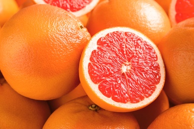 Photo of Many fresh ripe grapefruits as background, closeup