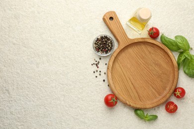 Photo of Cutting board, basil, oil, spices and tomatoes on white textured table, flat lay. Space for text