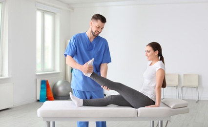 Photo of Physiotherapist working with female patient in clinic