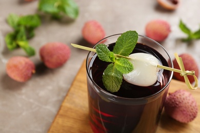 Lychee cocktail with mint and fresh fruits on grey table, closeup
