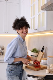 Photo of Smiling food blogger cooking in kitchen at home