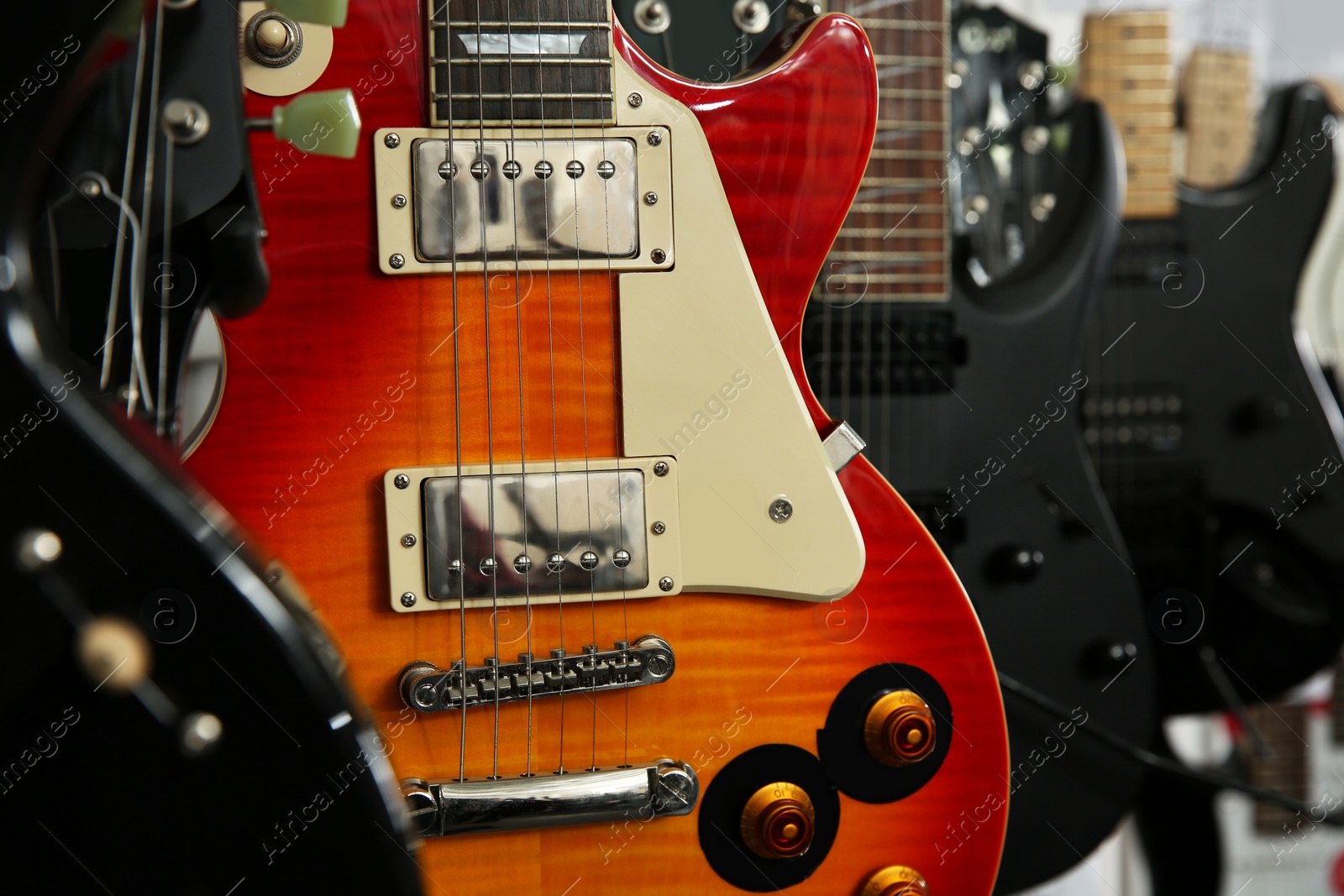 Photo of Modern electric guitars in music store, closeup