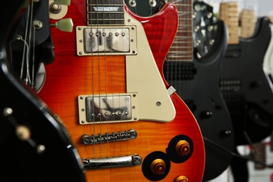 Photo of Modern electric guitars in music store, closeup