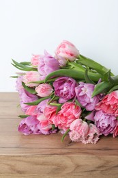 Photo of Beautiful bouquet of colorful tulip flowers on wooden table