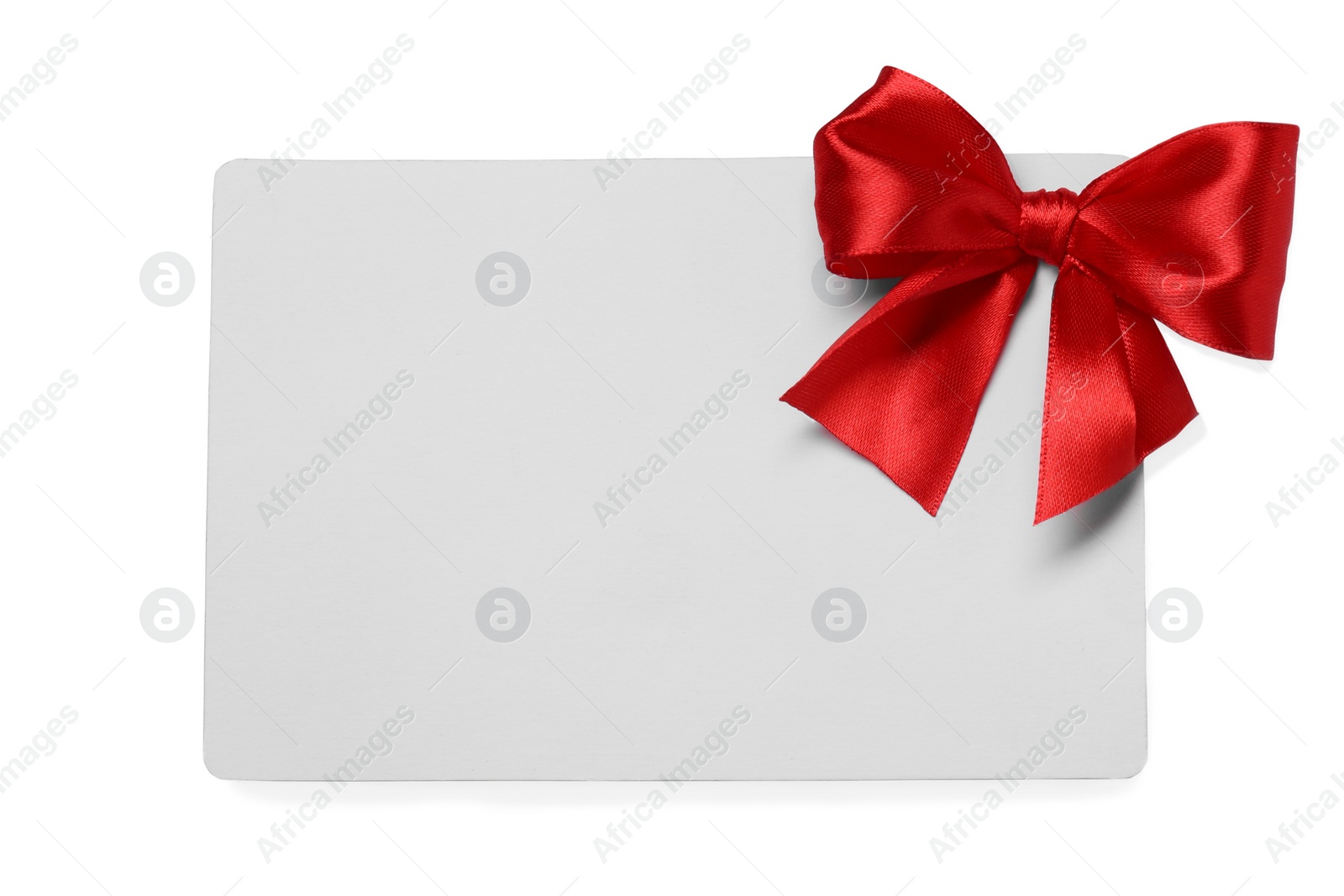 Photo of Blank gift card with red bow isolated on white, top view