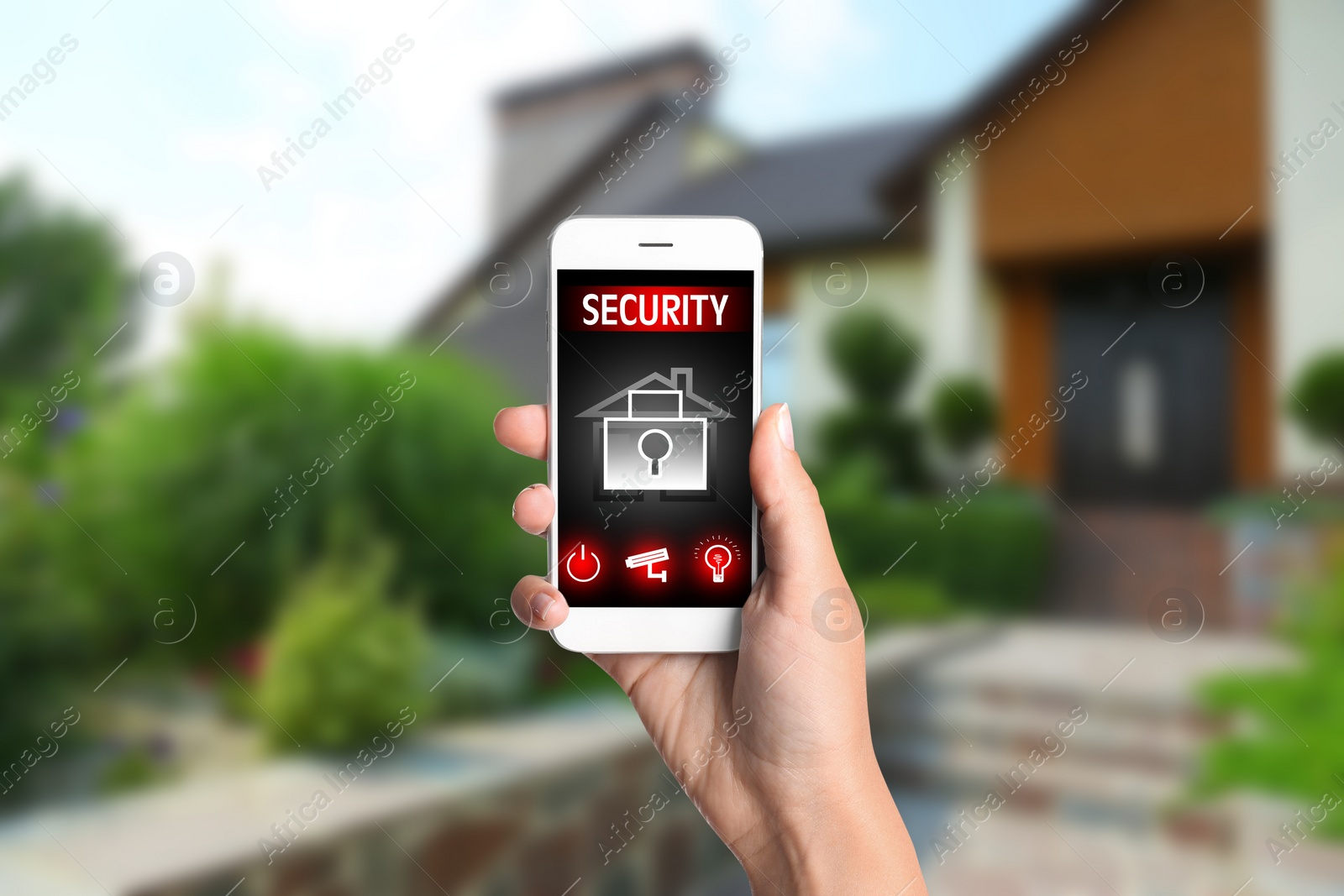 Image of Woman monitoring modern CCTV cameras on smartphone near her house, closeup. Home security system